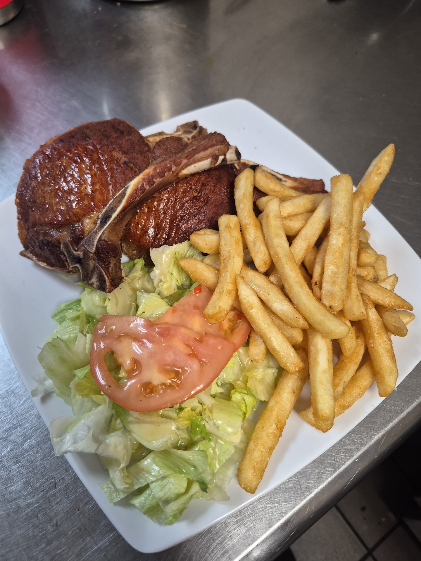 Chuleta a la parrilla con papas fritas y ensalada