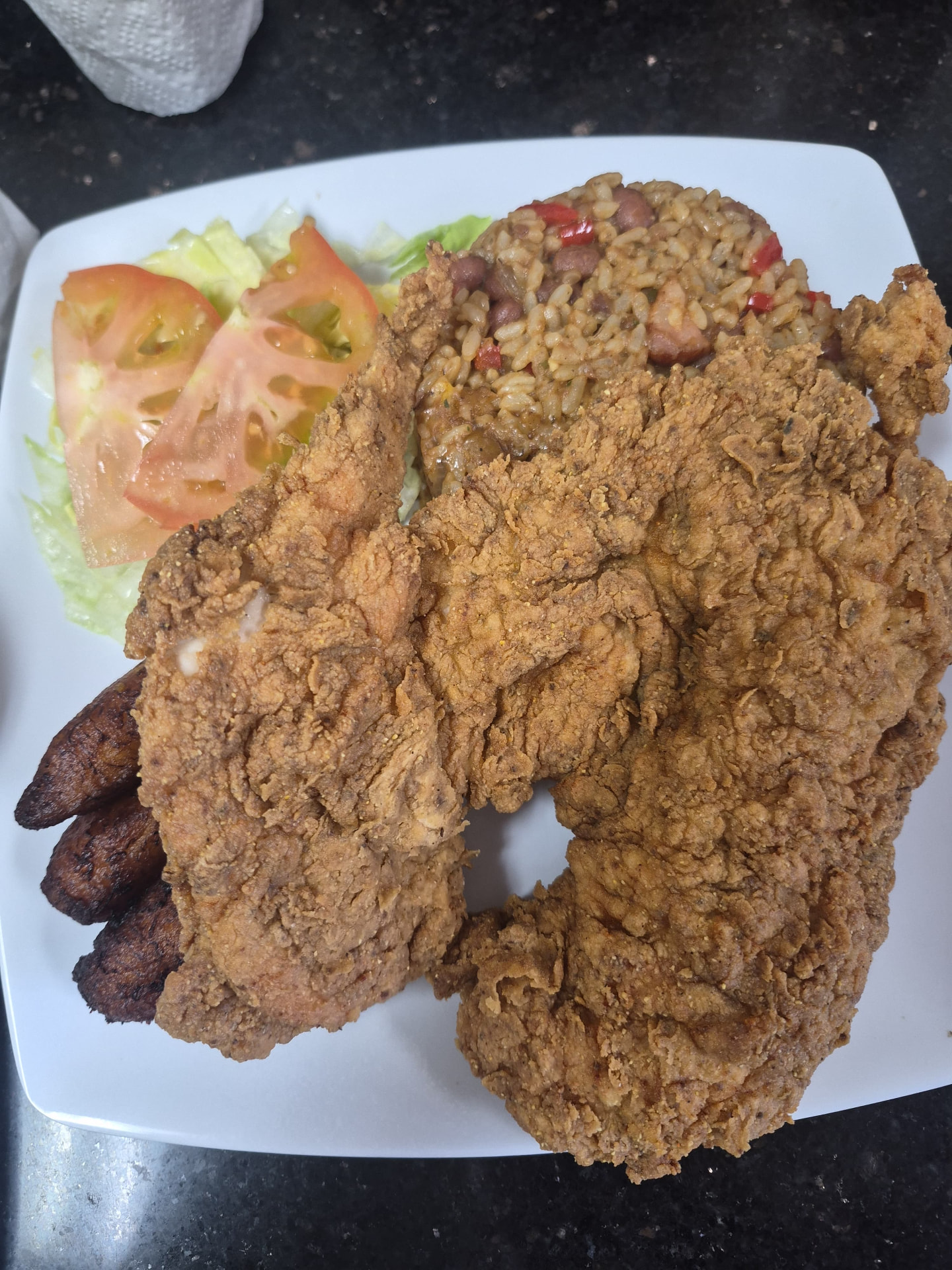 Chuleta frita con arroz con habichuelas, ensalada y maduros