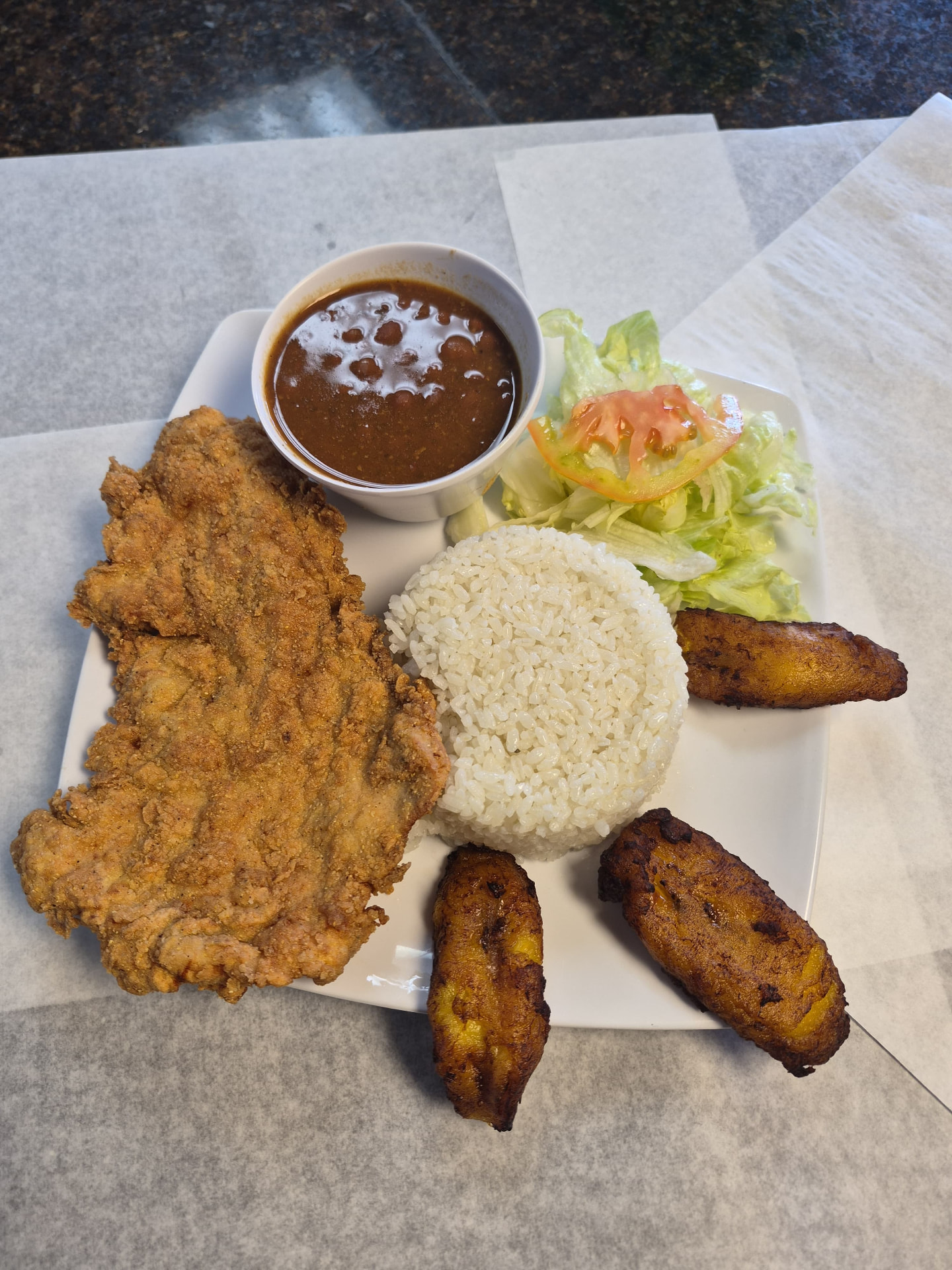 Pechuga empanizada con arroz, habichuelas, ensalada y maduros